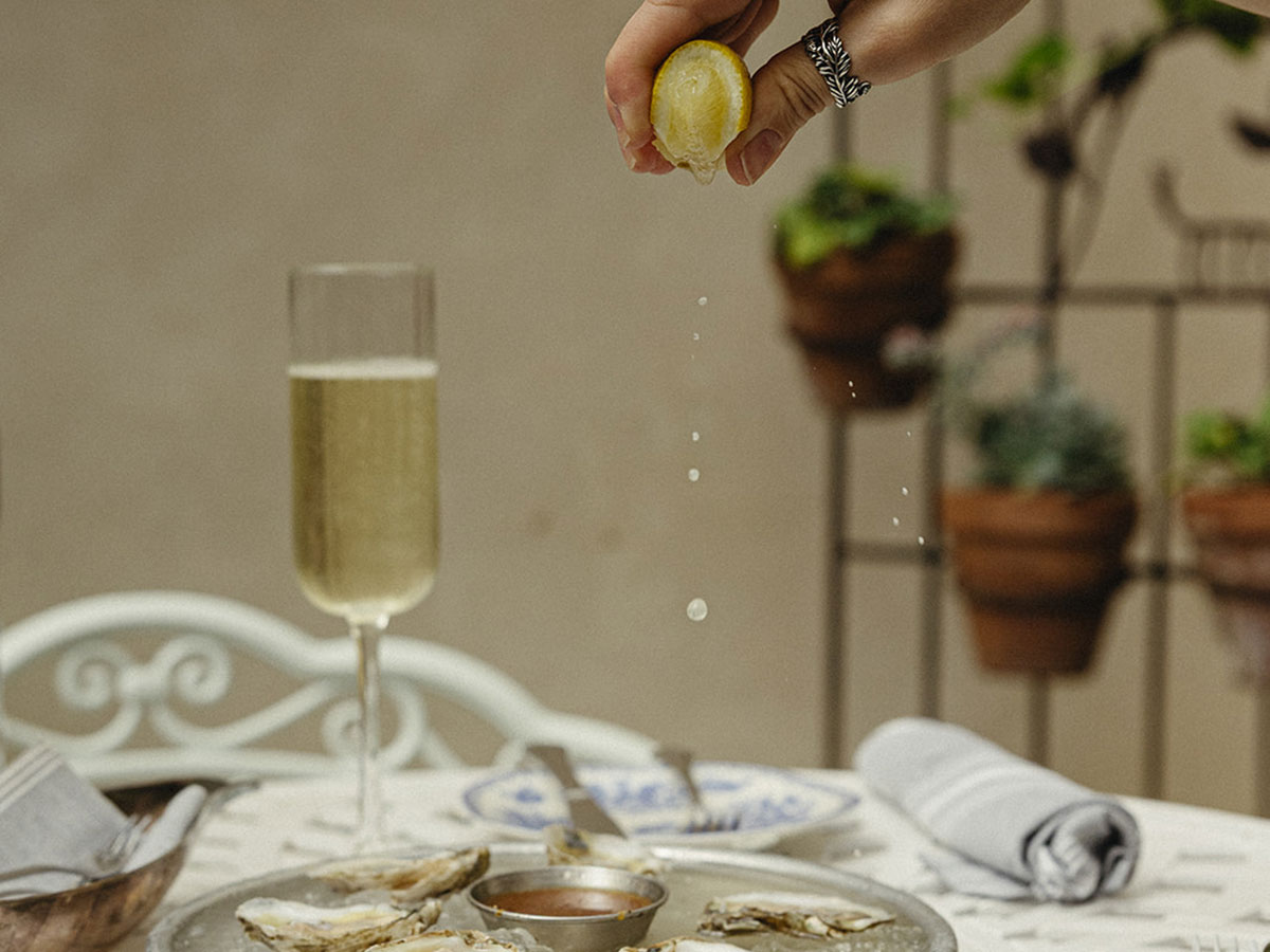 1G7A5946_websize_1200x900 hand squeezing lemon on oysters