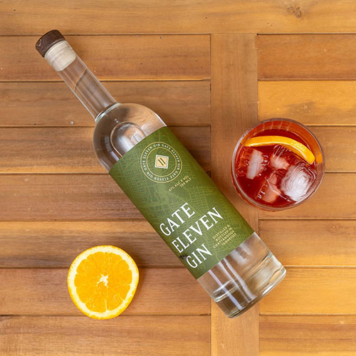 bottle of gate 11 gin with a cocktail and lemon slice