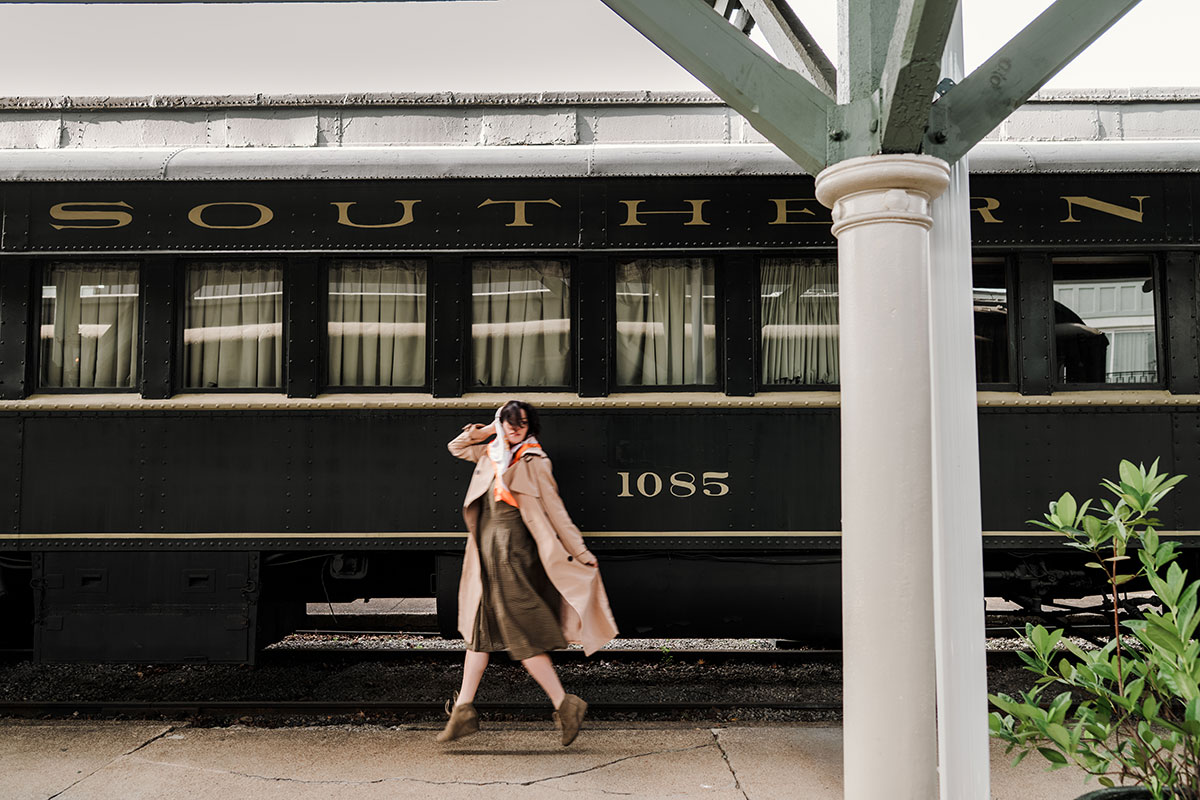 woman skipping elegantly next to a train